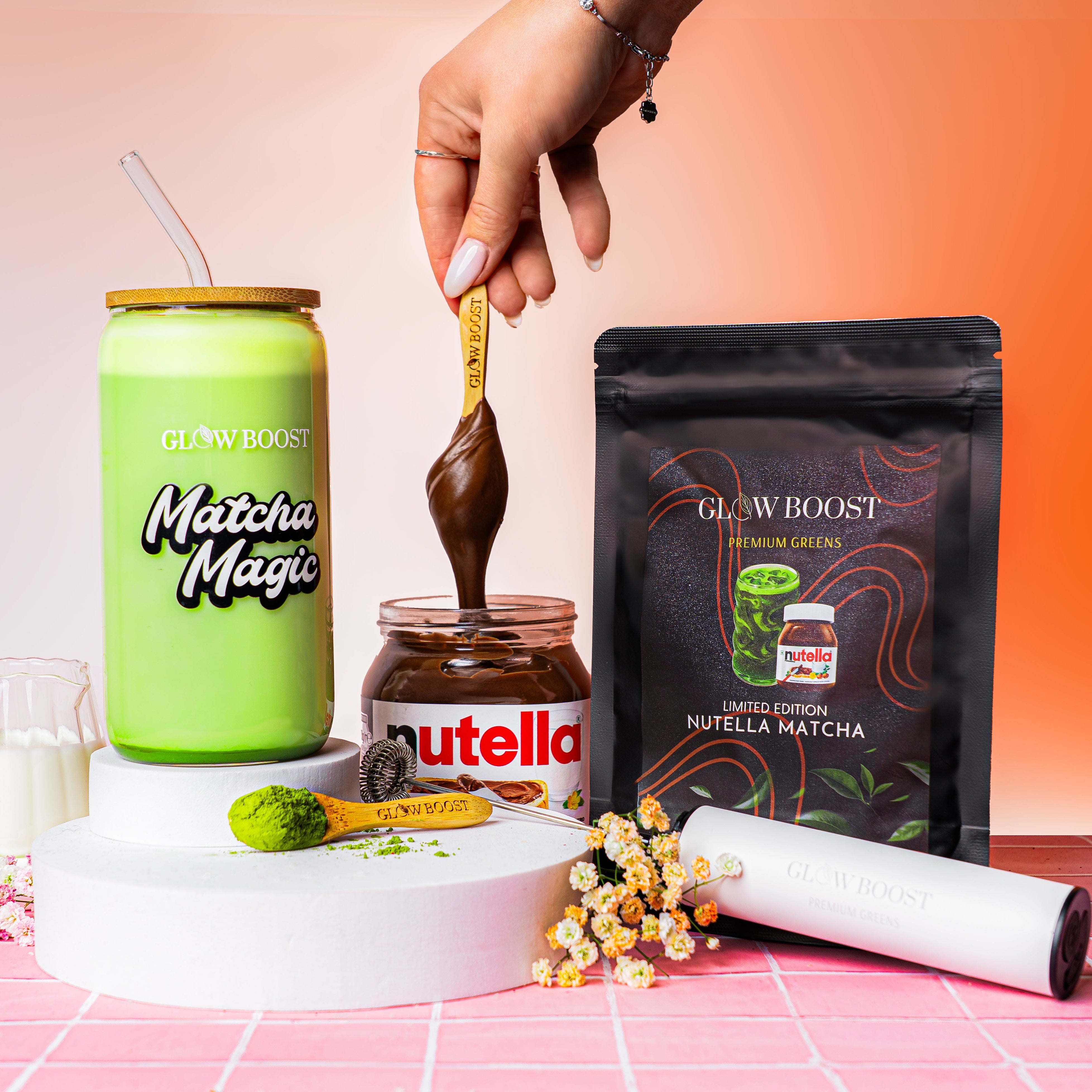 Glow Boost Matcha Magic can, Nutella jar, and package on a pink and orange gradient background.